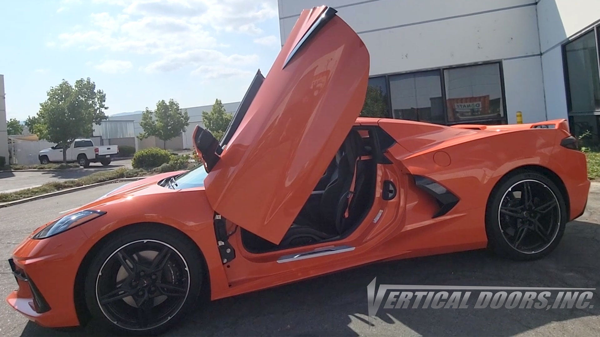 Chevy Corvette C8 Sebring orange featuring Vertical Doors, Inc., vertical lambo door conversion kit.